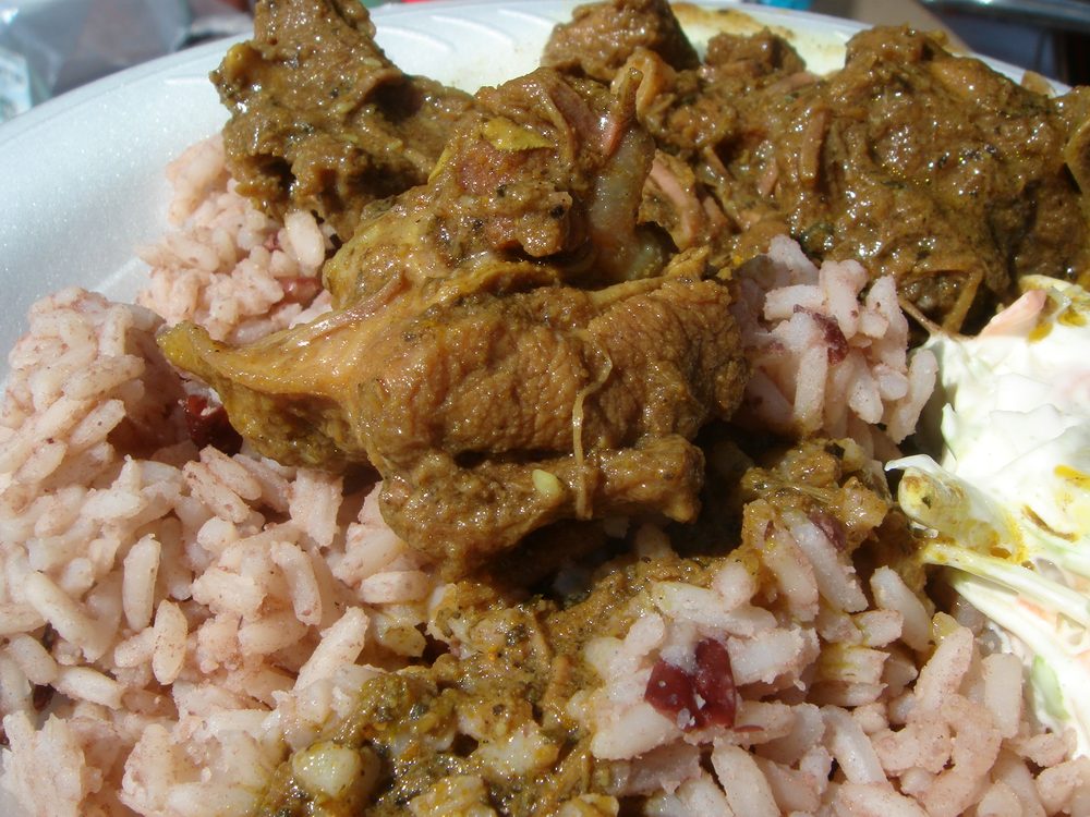 Curry goat simmered in savoury spiced sauce served over rice