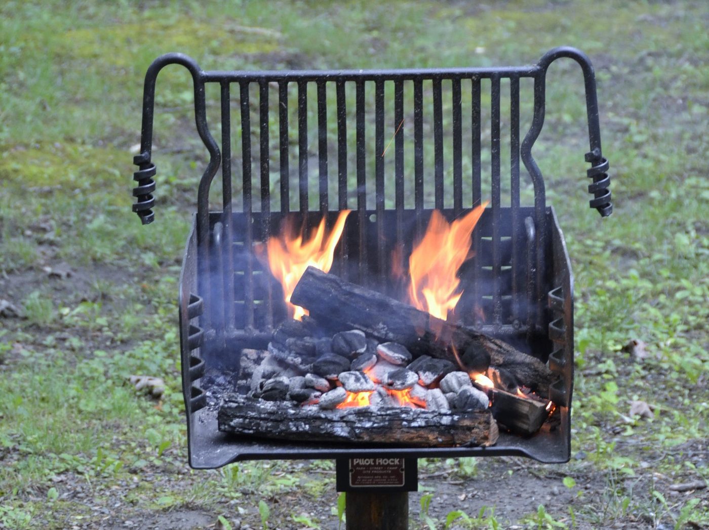 Open flame jerk grill glowing with hot coals
